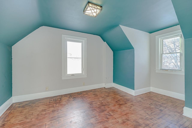 additional living space with hardwood / wood-style flooring and lofted ceiling