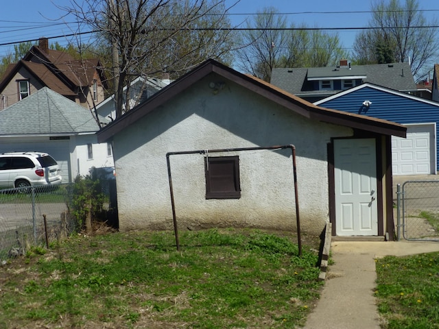 view of side of property with a garage, fence, and stucco siding