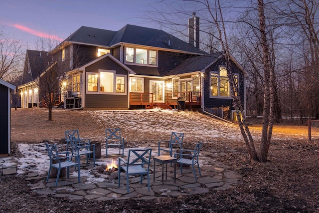 snow covered house featuring an outdoor fire pit and a patio