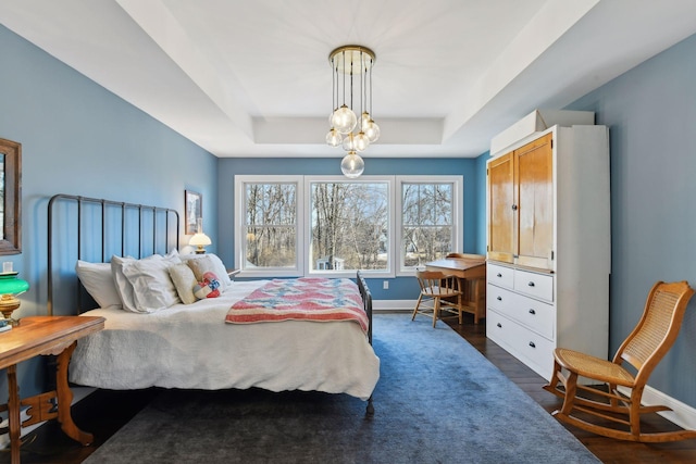 bedroom featuring dark hardwood / wood-style floors and a tray ceiling