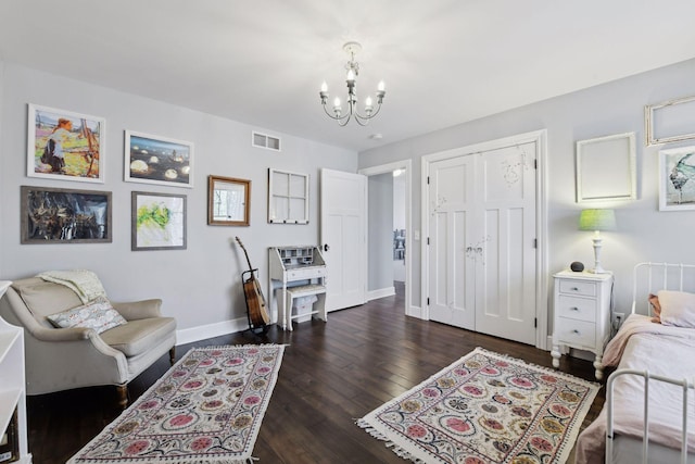 interior space featuring dark wood-type flooring, a notable chandelier, and a closet