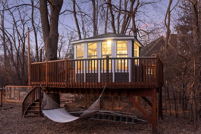 back house at dusk with a deck