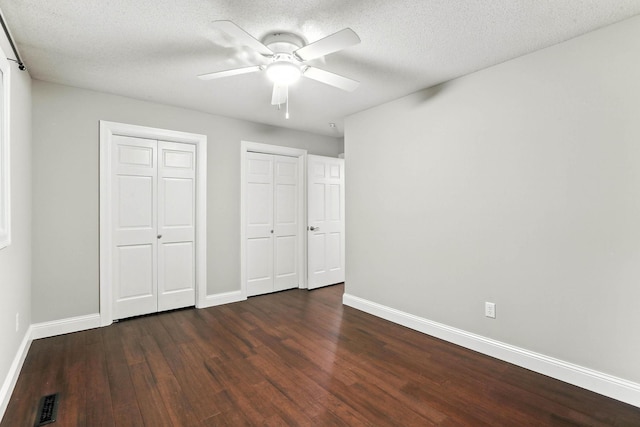 8385 Pleasant View Dr, Mounds View, MN 55112 - unfurnished bedroom with multiple closets, dark wood finished floors, ceiling fan, and a textured ceiling