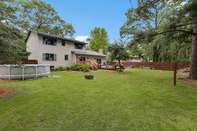 8385 Pleasant View Dr, Mounds View, MN 55112 - back of property featuring a deck, a covered pool, a chimney, and an outdoor fire pit