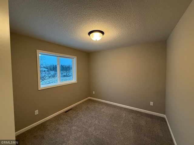 carpeted spare room with a textured ceiling