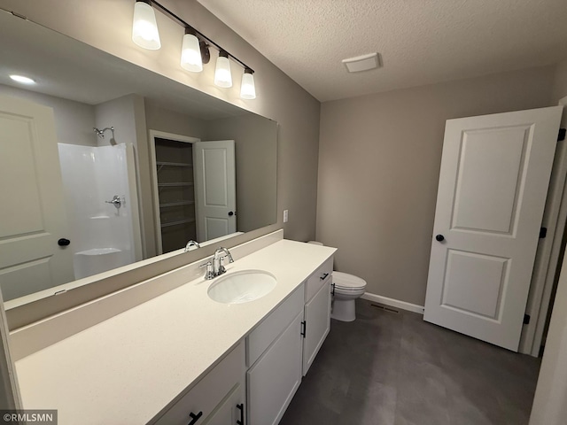 bathroom featuring a shower, a textured ceiling, toilet, and vanity