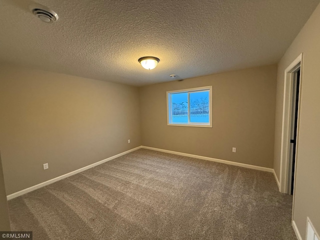 carpeted empty room featuring a textured ceiling