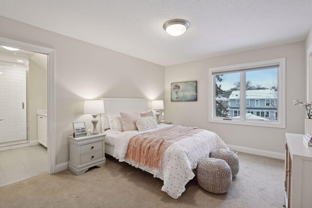 carpeted bedroom featuring a textured ceiling and connected bathroom