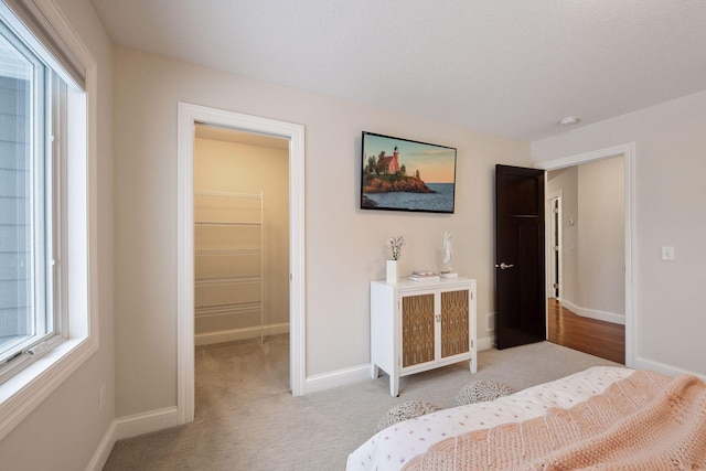 unfurnished bedroom with a walk in closet, light carpet, and a closet