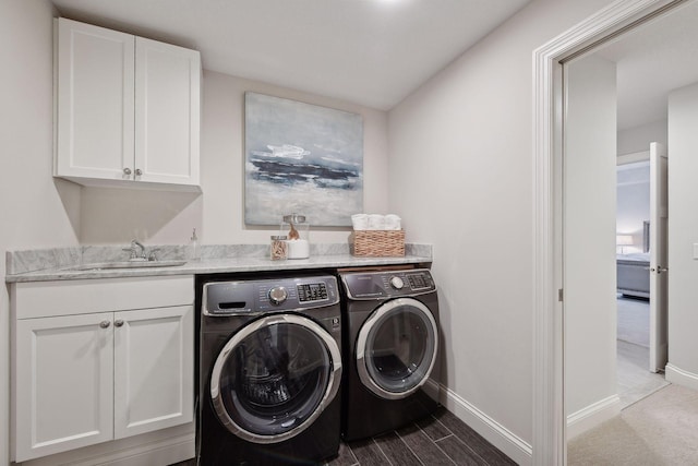 laundry area featuring cabinets, washing machine and dryer, and sink