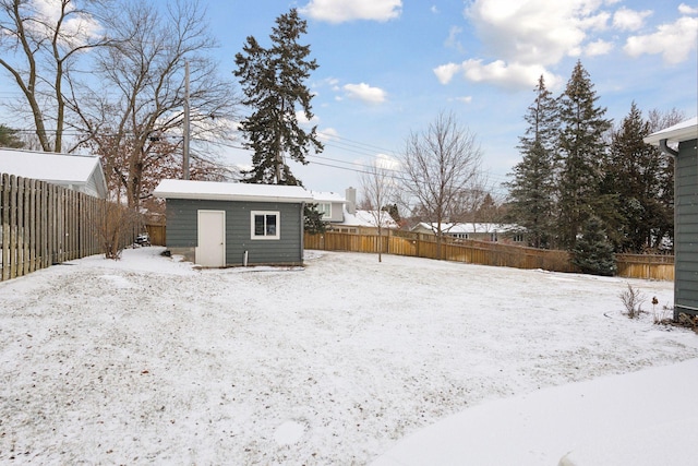 yard covered in snow with a storage unit