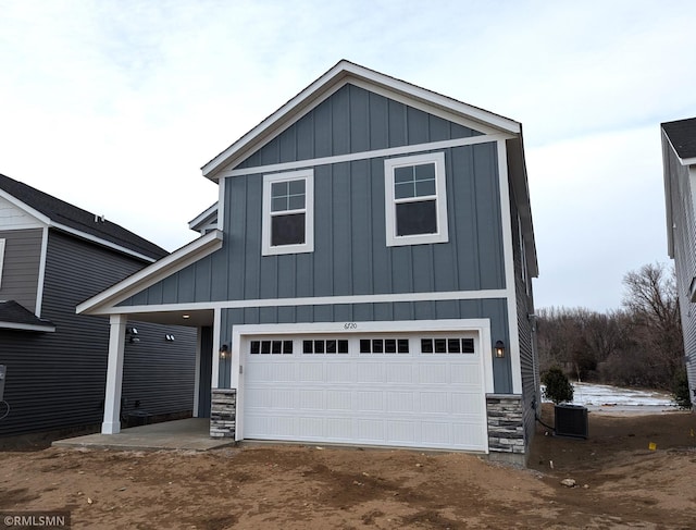 view of front of property featuring a garage and central AC unit