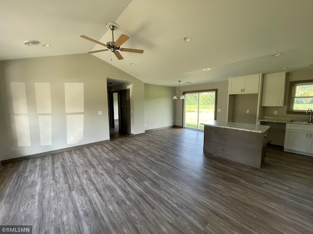 unfurnished living room featuring dark hardwood / wood-style floors, ceiling fan, lofted ceiling, and sink