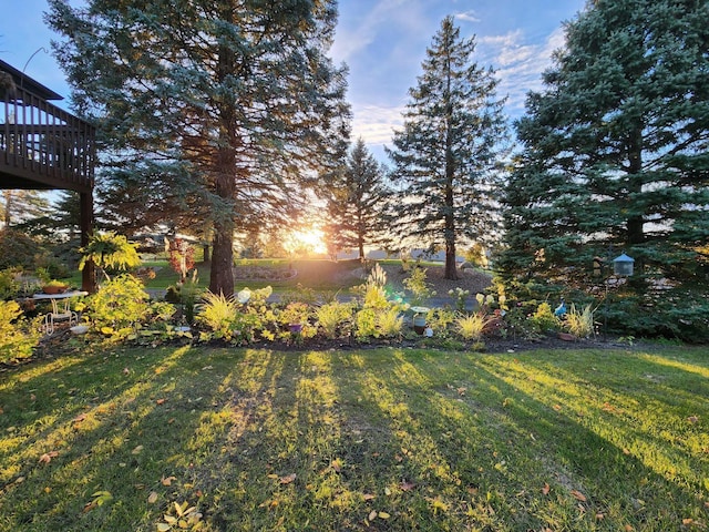 yard at dusk featuring a deck