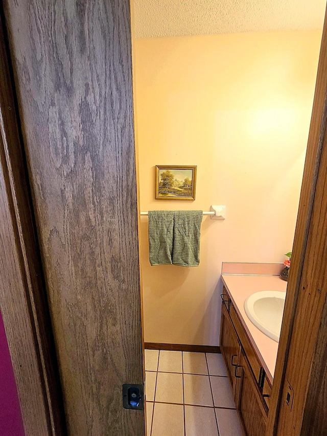 bathroom with tile patterned flooring, vanity, and a textured ceiling