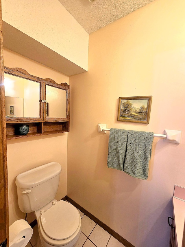 bathroom featuring toilet, a textured ceiling, and tile patterned floors