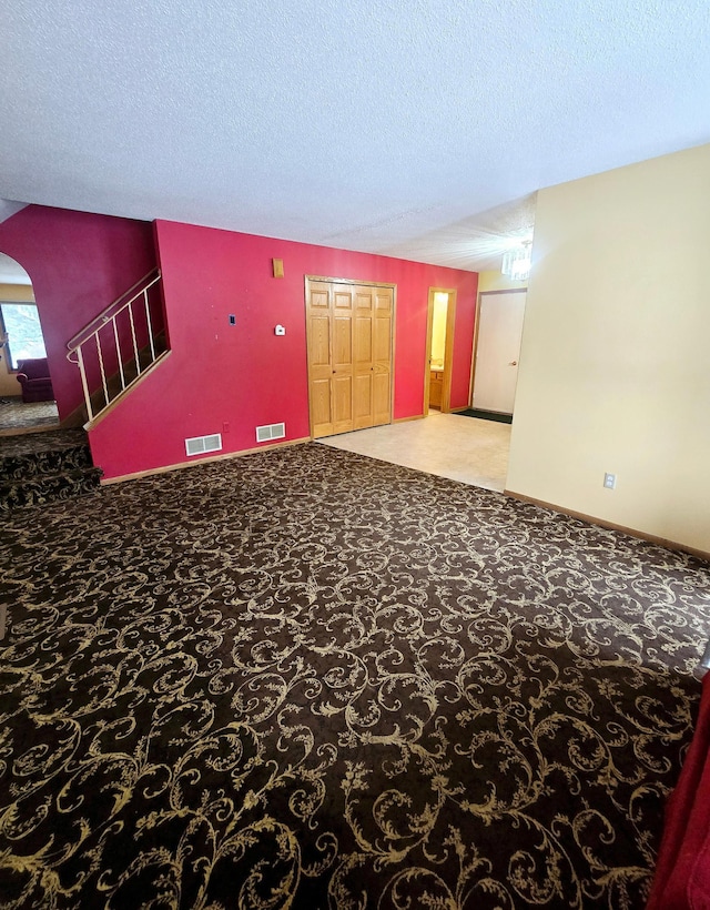 interior space featuring light carpet and a textured ceiling