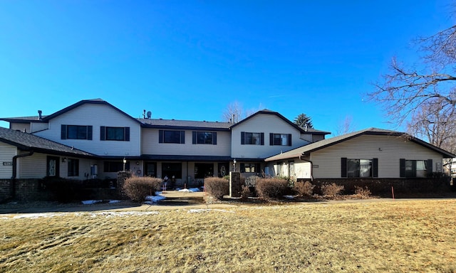 rear view of property featuring a yard