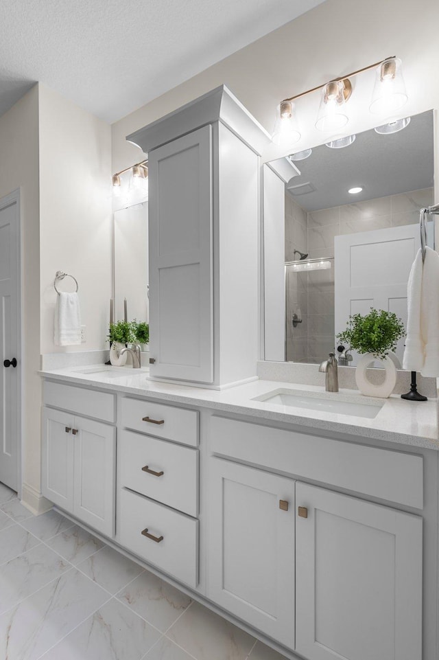 bathroom featuring vanity, a textured ceiling, and walk in shower