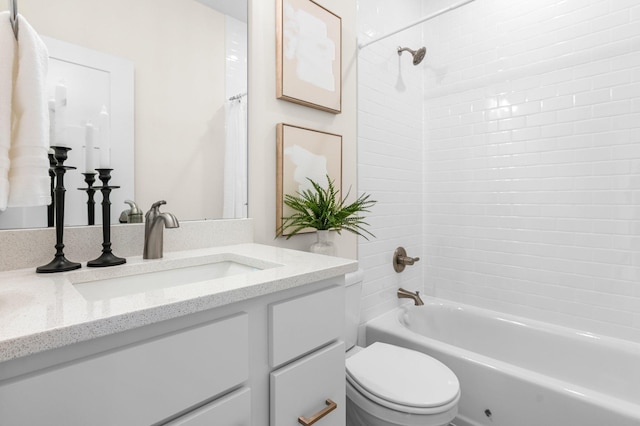 full bathroom featuring toilet, vanity, and tiled shower / bath