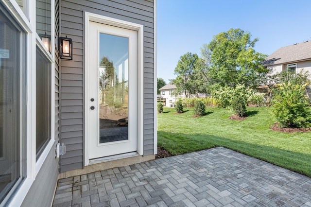 property entrance featuring a patio area and a yard