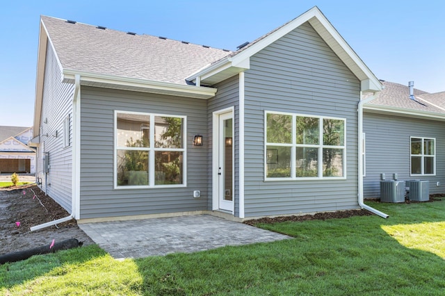 rear view of house featuring a patio area, a lawn, and central air condition unit