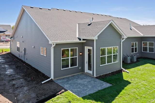 rear view of house featuring central AC unit, a patio area, and a yard