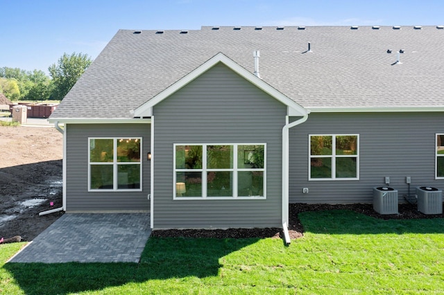 back of house featuring central AC and a yard