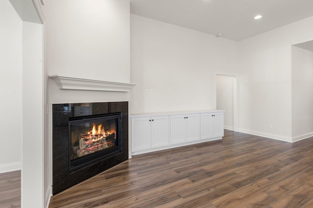 unfurnished living room with dark wood-type flooring and a fireplace