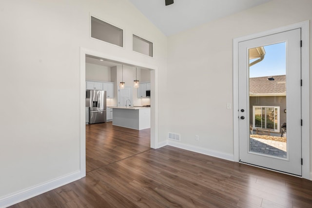 interior space featuring plenty of natural light, dark hardwood / wood-style floors, and vaulted ceiling