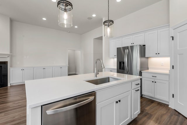 kitchen with a center island with sink, appliances with stainless steel finishes, white cabinetry, and sink