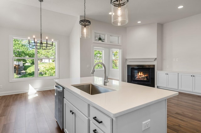 kitchen featuring white cabinetry, an island with sink, pendant lighting, stainless steel dishwasher, and sink