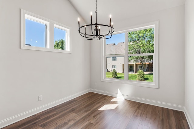 unfurnished dining area with lofted ceiling, dark hardwood / wood-style flooring, and a chandelier