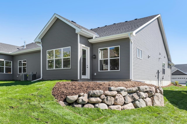 rear view of house featuring a lawn and central AC unit