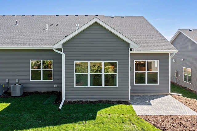 rear view of property with central AC, a patio area, and a yard