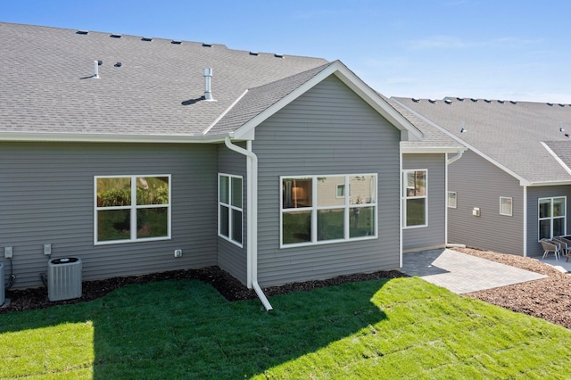 rear view of house featuring a lawn, central AC, and a patio area