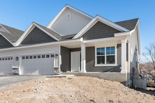 view of front of house with a garage, a porch, and central air condition unit