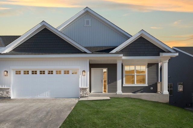 craftsman-style home with a garage, a yard, and covered porch