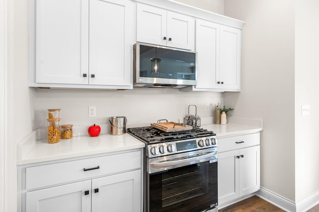 kitchen featuring dark wood-type flooring, stainless steel appliances, and white cabinetry