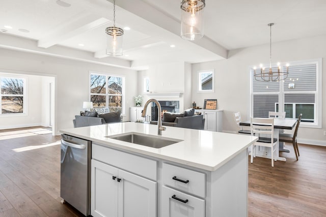 kitchen featuring hardwood / wood-style flooring, a center island with sink, dishwasher, white cabinets, and sink