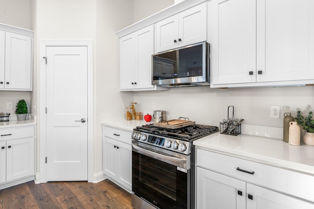 kitchen featuring dark wood-type flooring, appliances with stainless steel finishes, and white cabinets