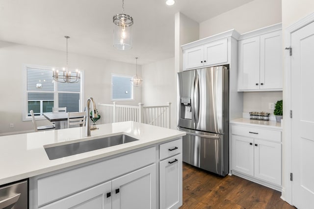 kitchen featuring white cabinets, decorative light fixtures, sink, stainless steel fridge, and dark hardwood / wood-style floors