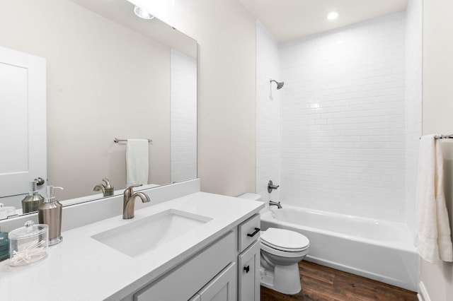 full bathroom featuring toilet, tiled shower / bath, wood-type flooring, and vanity