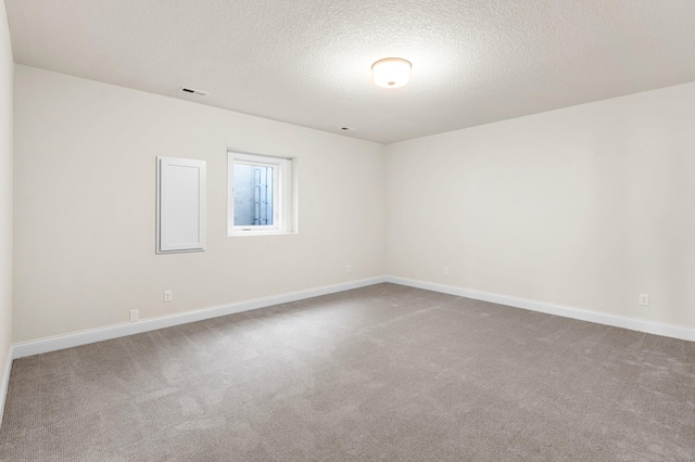 carpeted empty room with a textured ceiling