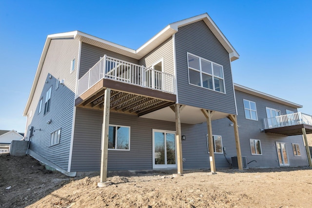 back of house with a wooden deck and cooling unit