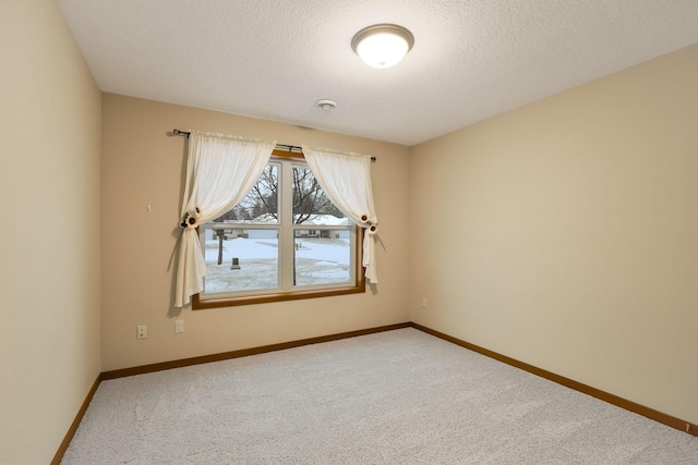 empty room with carpet flooring and a textured ceiling