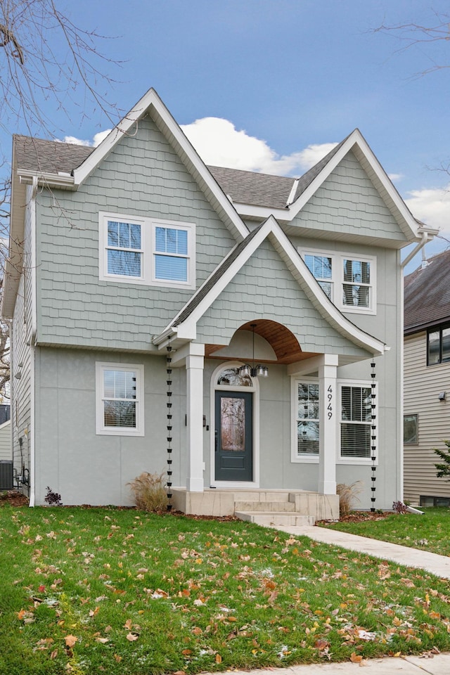 view of front of property with central AC unit and a front yard