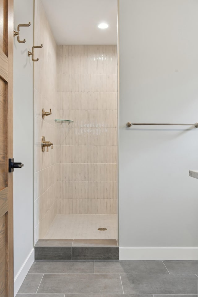 bathroom featuring tile patterned flooring and a tile shower