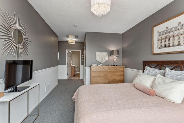 bedroom with an inviting chandelier, carpet, and a textured ceiling