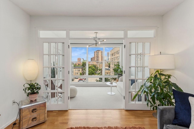 doorway featuring an inviting chandelier and light hardwood / wood-style flooring